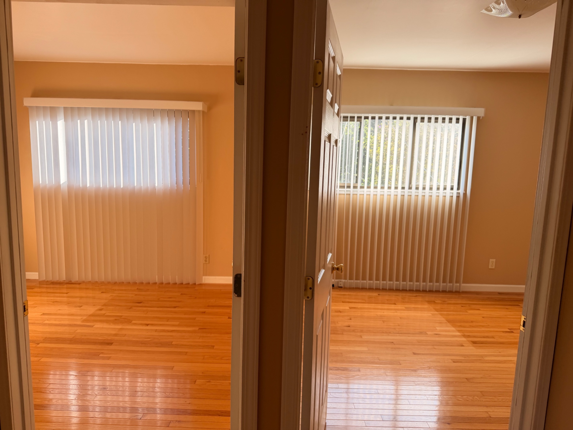 Two bedrooms across a hallway, both with hardwood floors