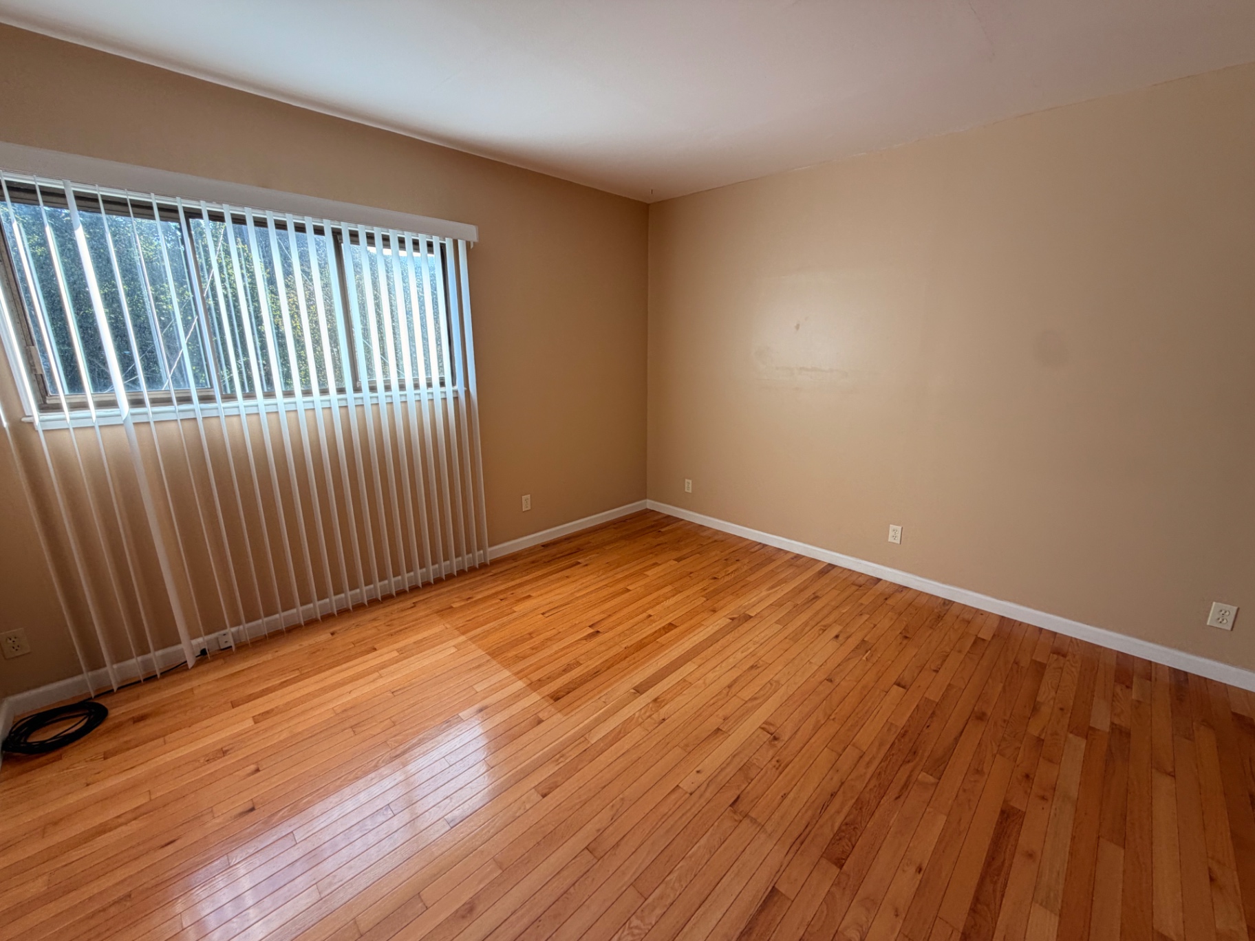 Corner bedroom with wide windows and hardwood floors