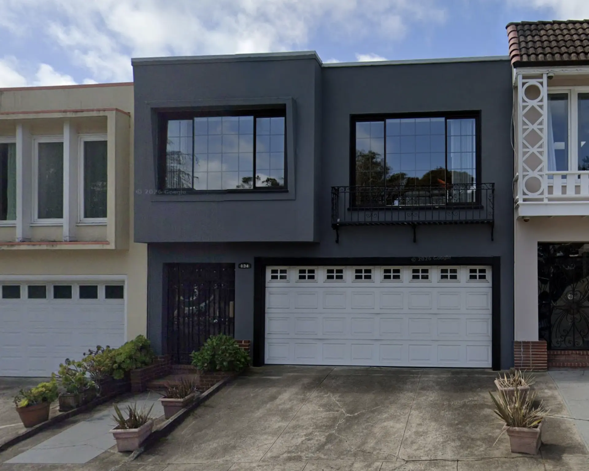 Front of the house, grey stucco facade with double garage