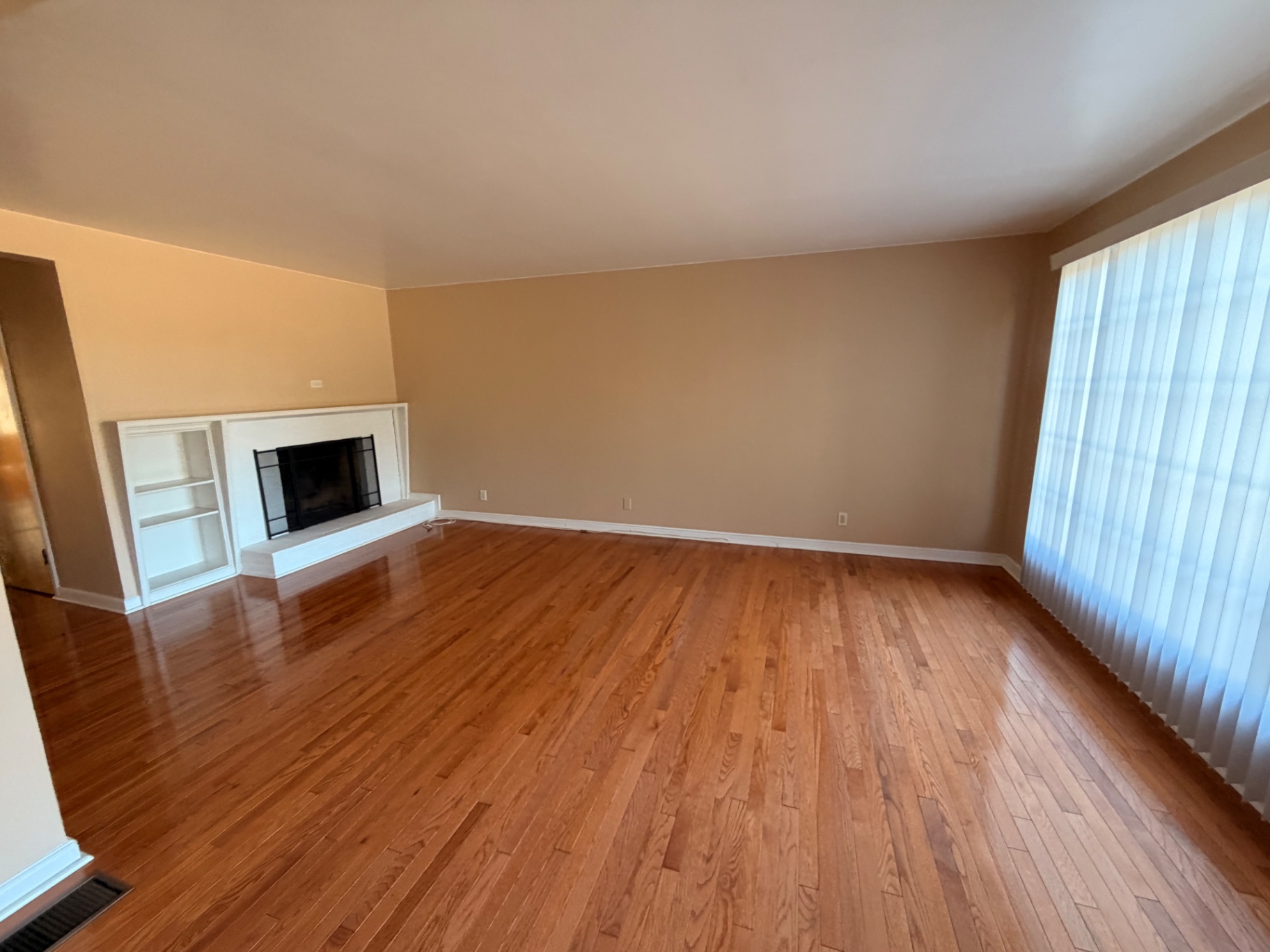 Living room with a white brick fireplace and built-in shelving
