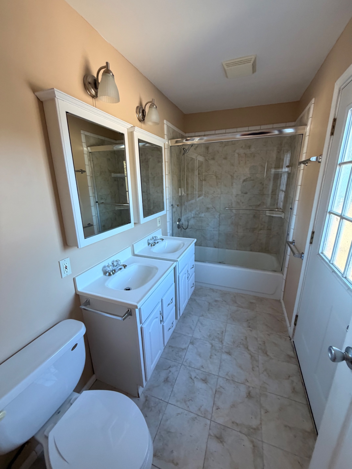 Full bathroom with a double vanity and tub shower
